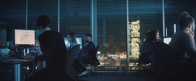 a group of people sitting at a desk in front of computer monitors