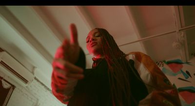 a woman with dreadlocks giving a thumbs up