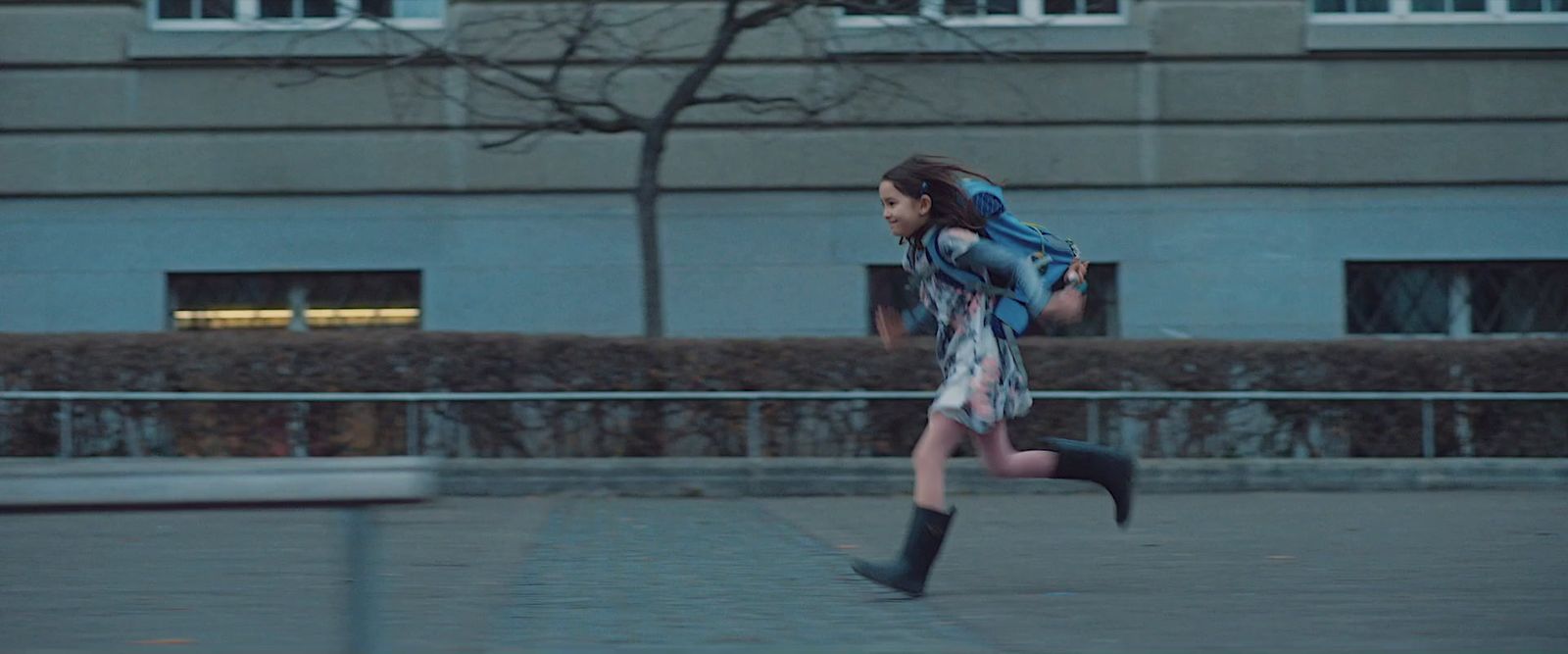 a woman with a backpack running down a sidewalk