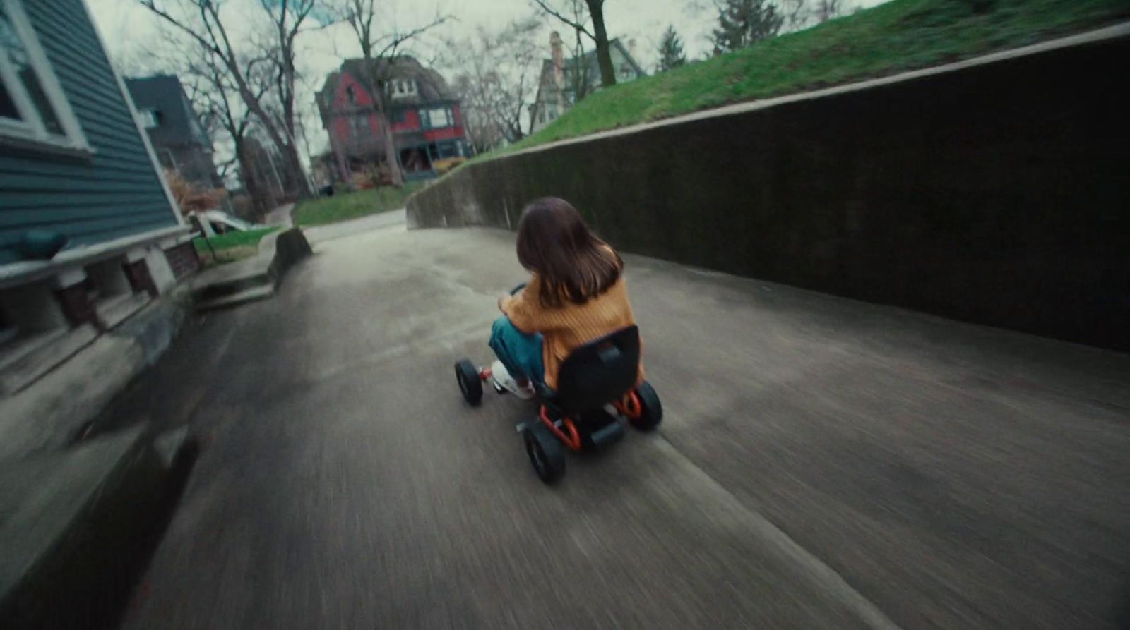 a young girl riding a skateboard down a street