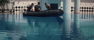 a couple of men sitting on top of a raft in a pool