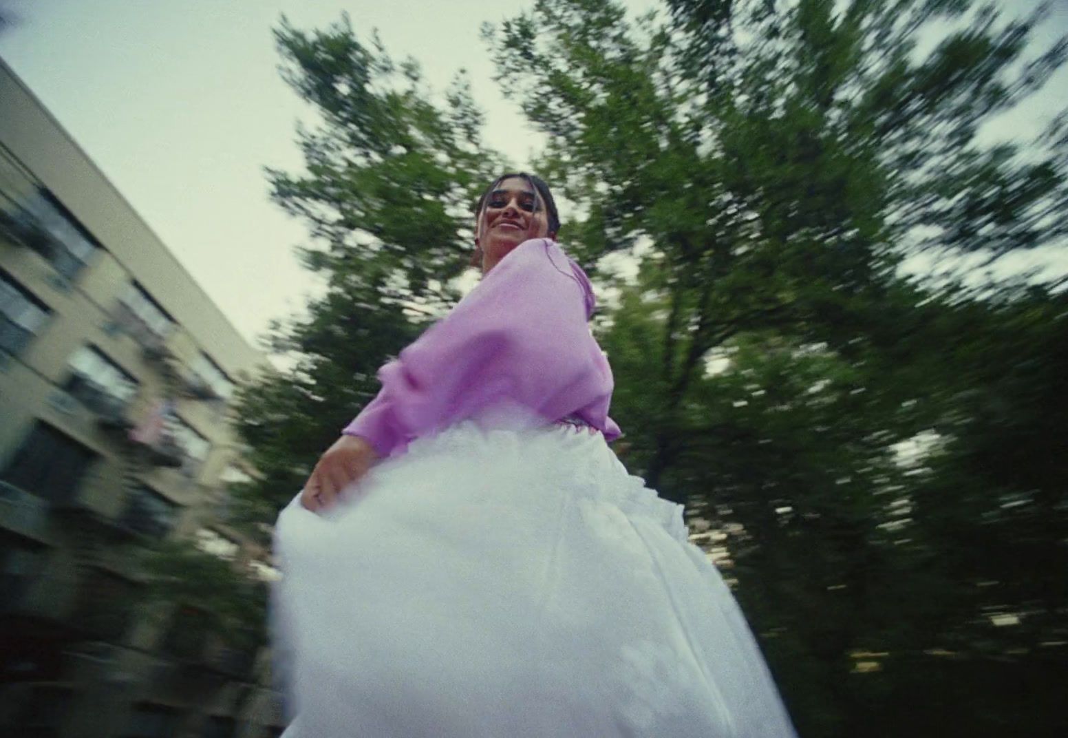 a woman in a white dress is riding a skateboard