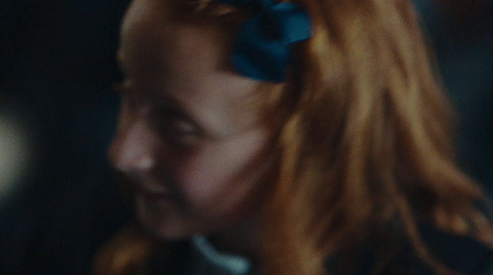 a close up of a person with a bow in her hair