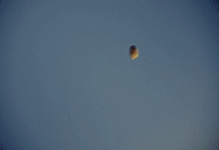 a hot air balloon flying through a blue sky