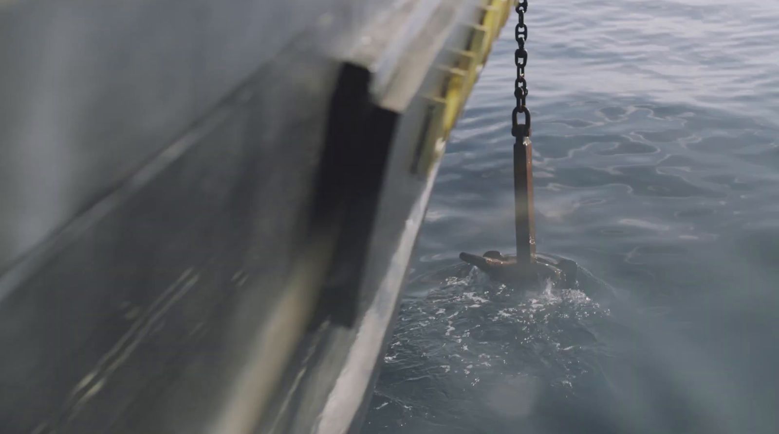 a boat in the water with a chain hanging from it's side