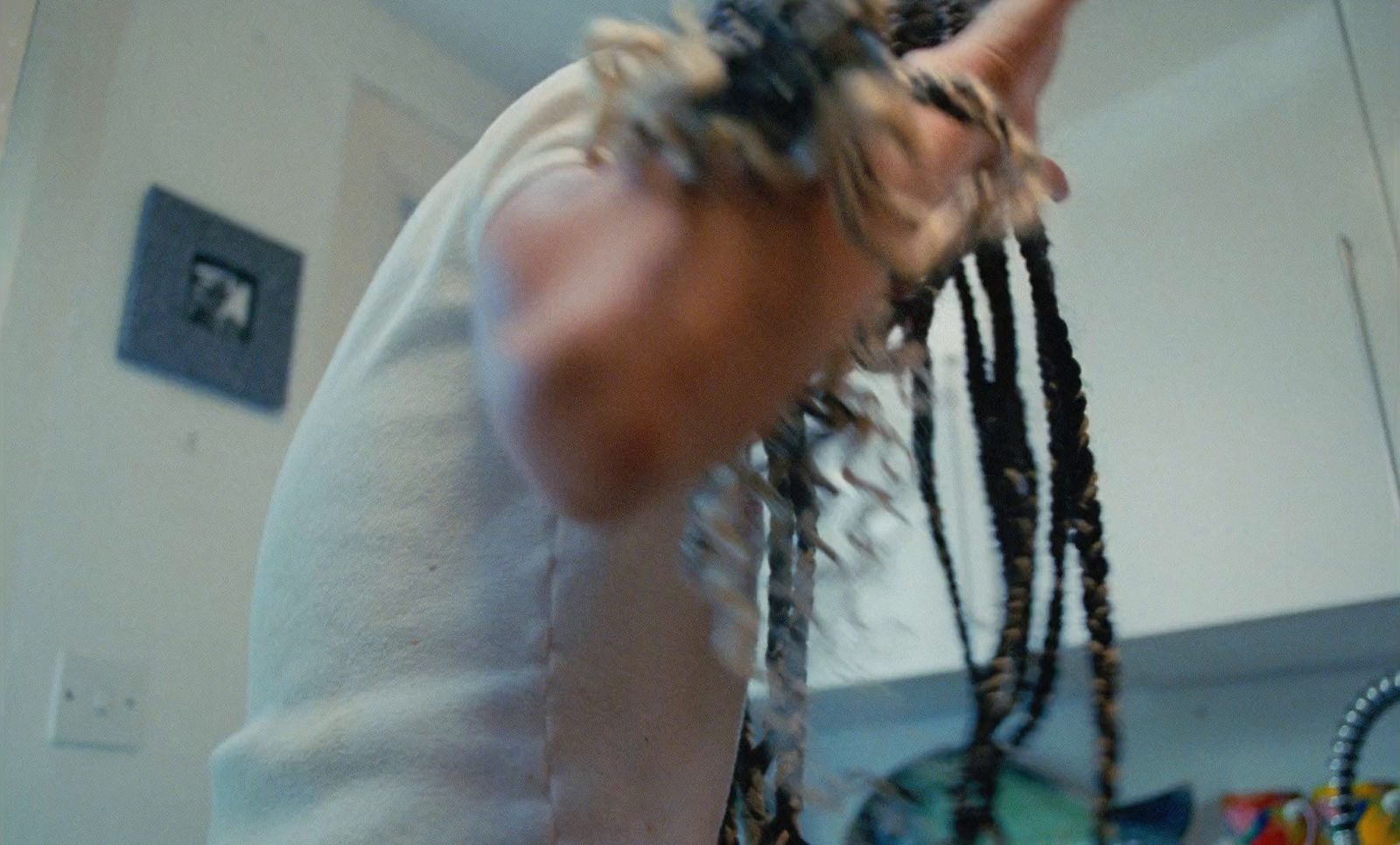 a man with dreadlocks standing in a kitchen