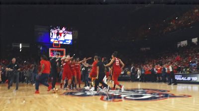 a group of men standing on top of a basketball court