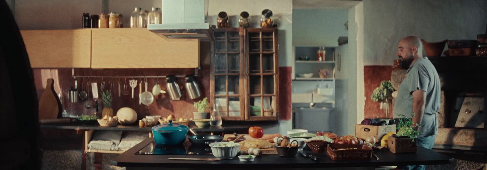 a man standing in a kitchen next to a table