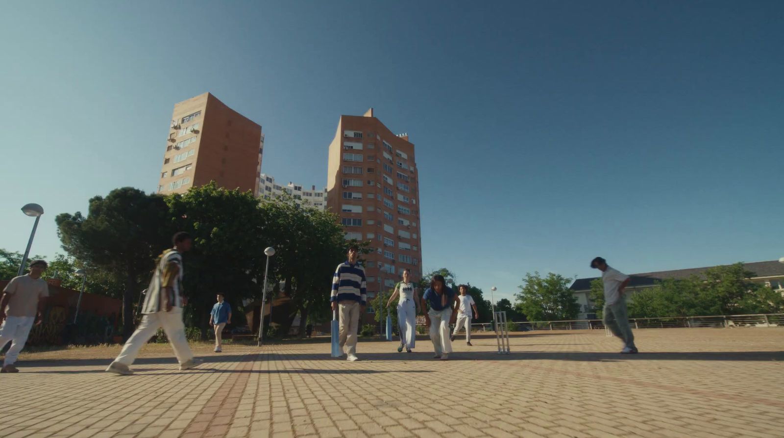 a group of people walking across a brick road