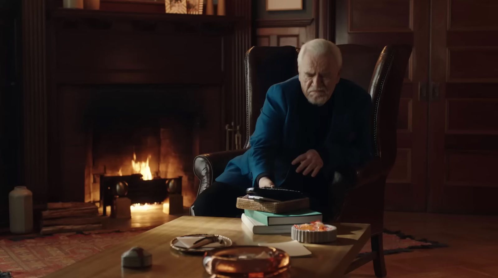 a man sitting in a chair in front of a fire place