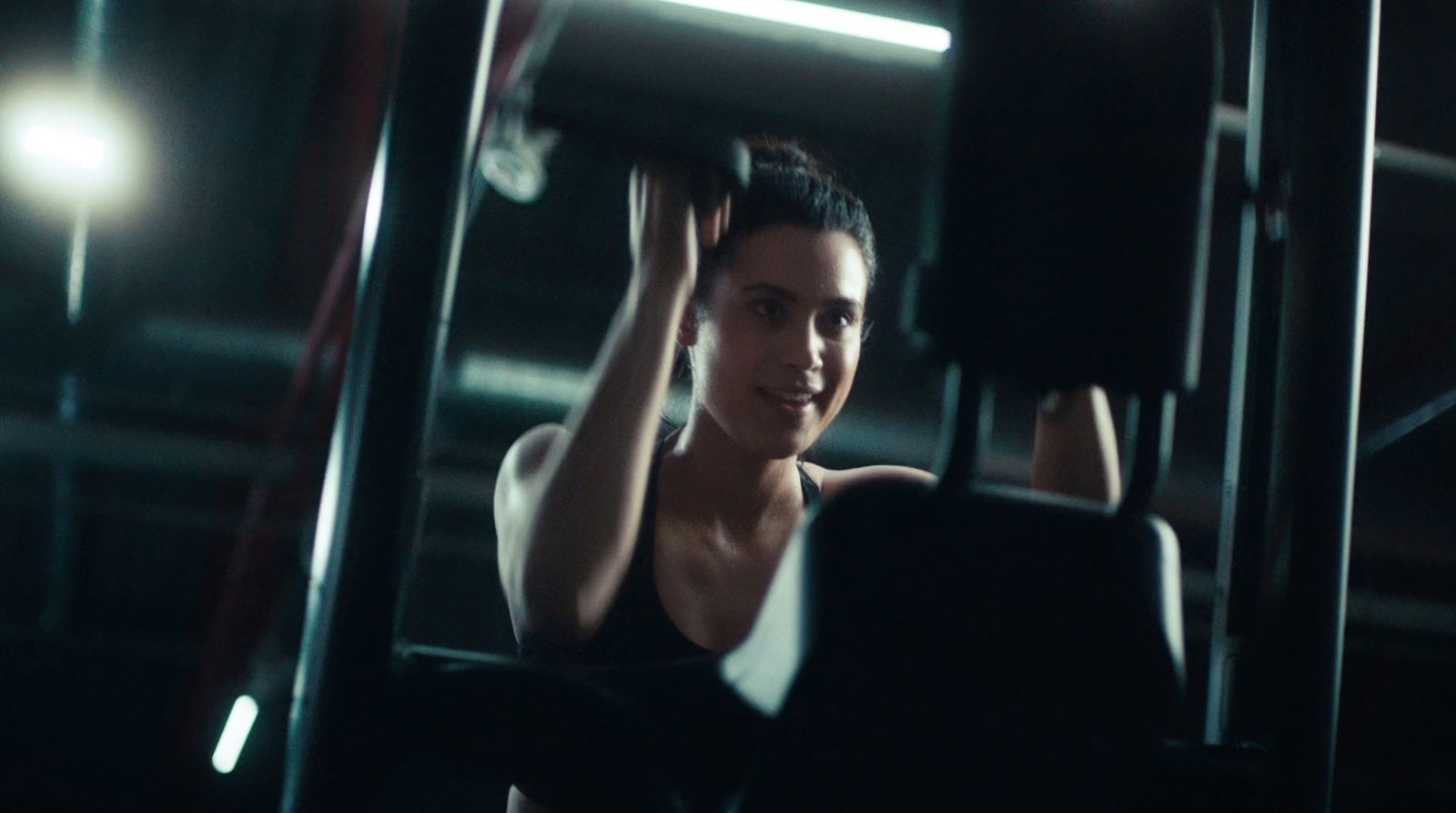 a woman sitting on a bench in a gym