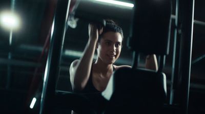 a woman sitting on a bench in a gym