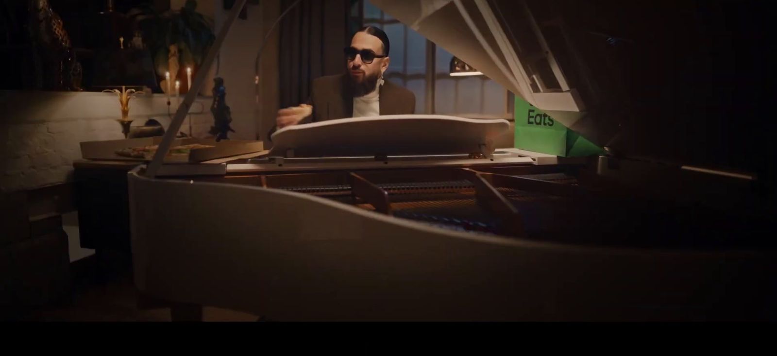 a man sitting at a piano in a dark room