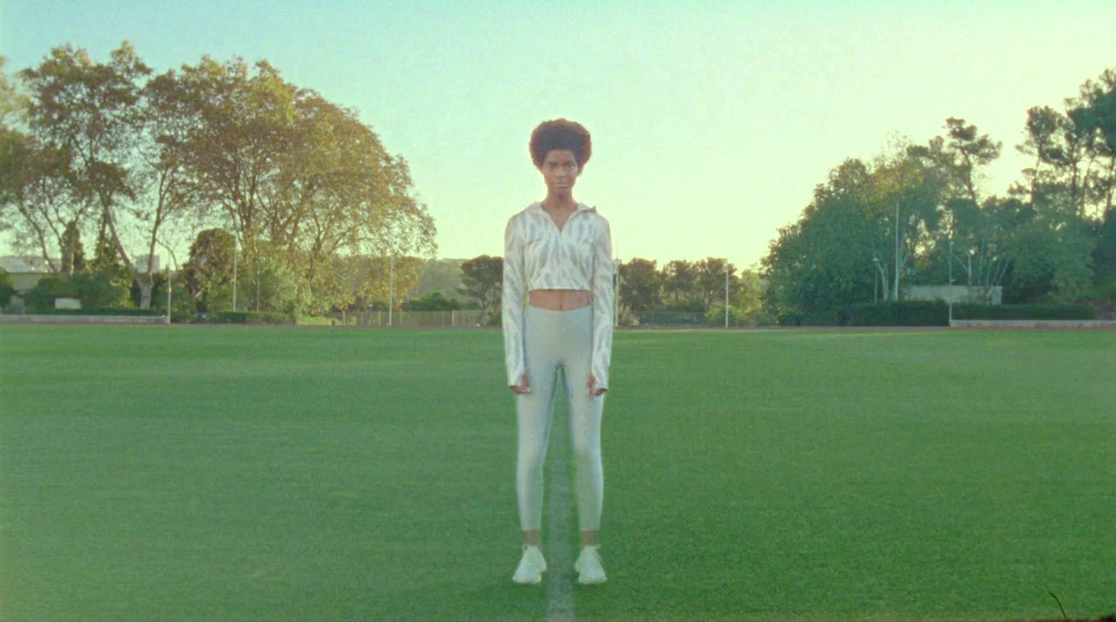 a woman standing on top of a lush green field