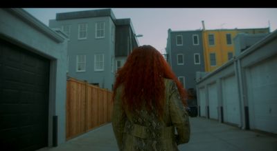 a woman with red hair walking down a street