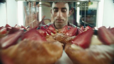 a man taking a picture of a bunch of pastries