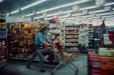 a woman pushing a child in a shopping cart