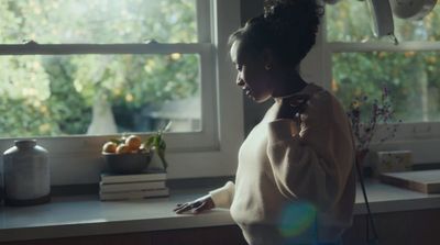 a woman standing in a kitchen next to a window