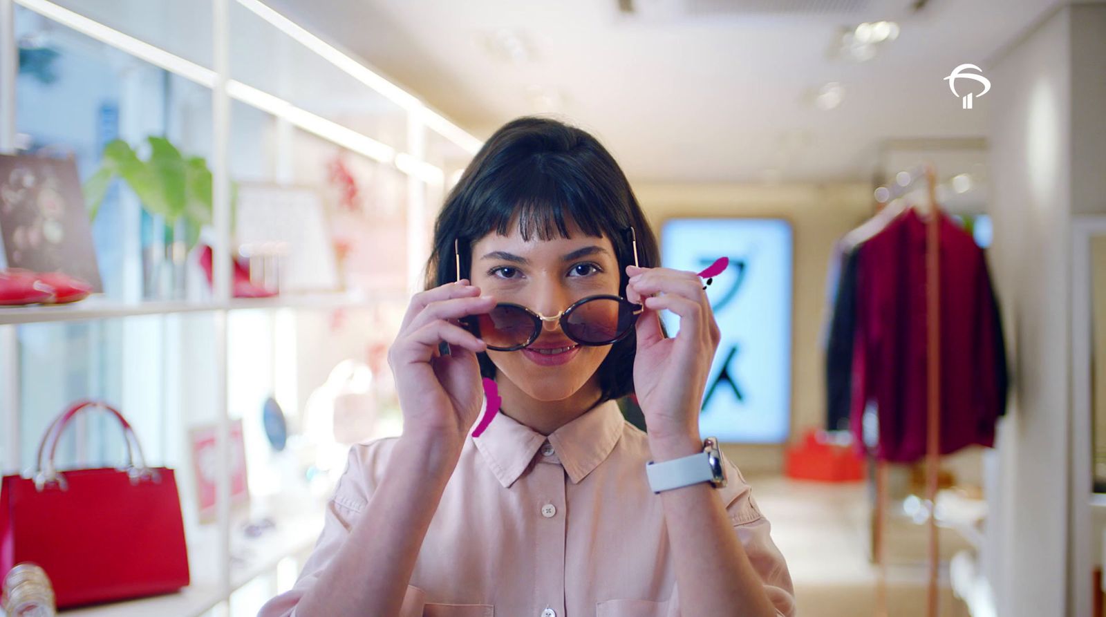 a woman holding up a pair of sunglasses in front of her face