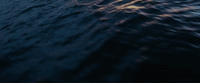 a large body of water with a boat in the distance