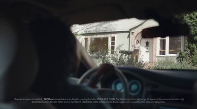 a man driving a car in front of a house