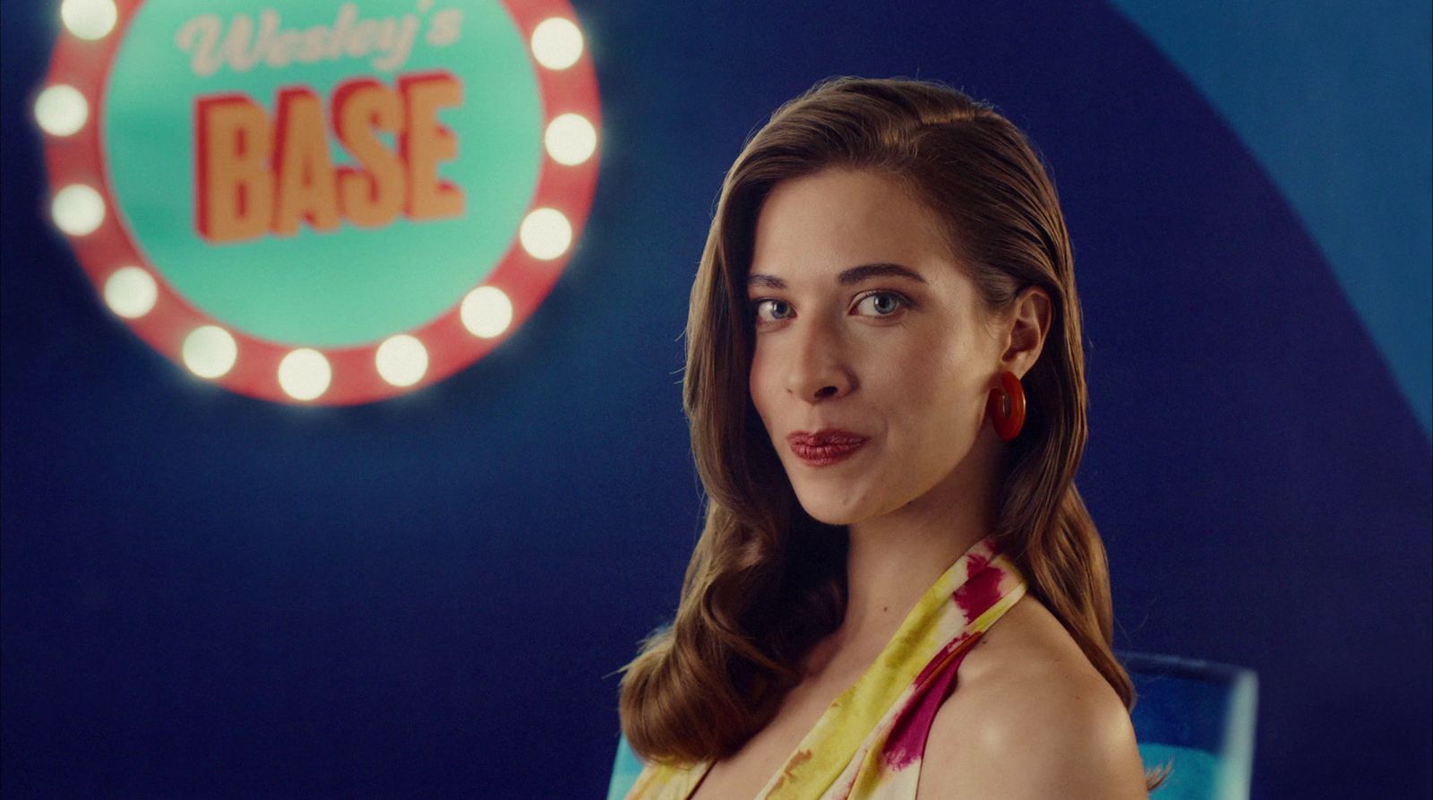 a woman standing in front of a neon sign