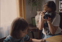 a woman taking a picture of a child with a camera