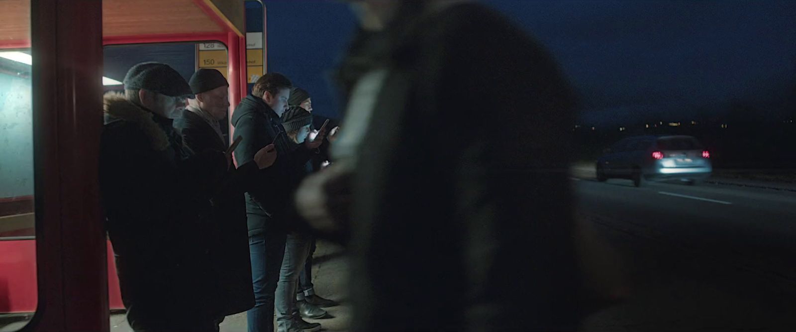 a group of people waiting on a bus at night