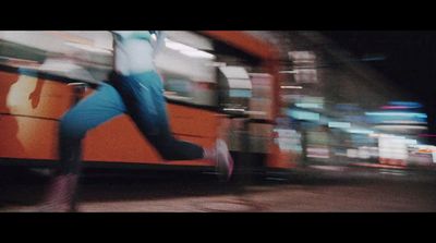 a blurry photo of a person running in front of a bus