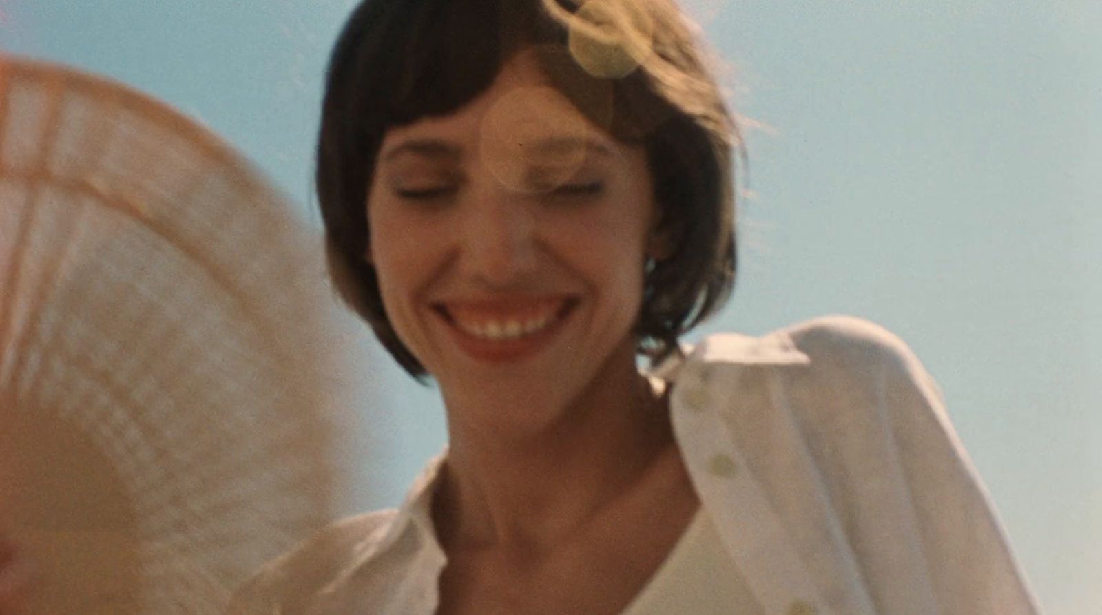 a woman smiling and holding a white frisbee