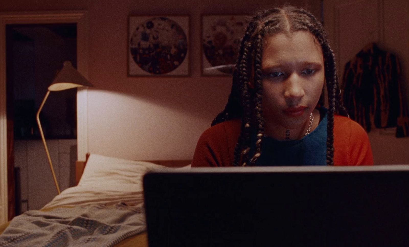 a woman with dreadlocks looking at a laptop