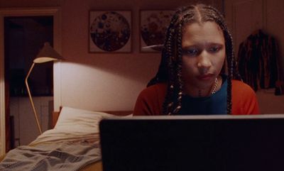 a woman with dreadlocks looking at a laptop