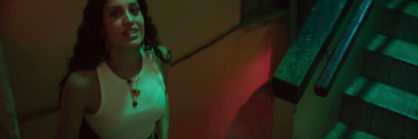 a woman standing in a room with a green light