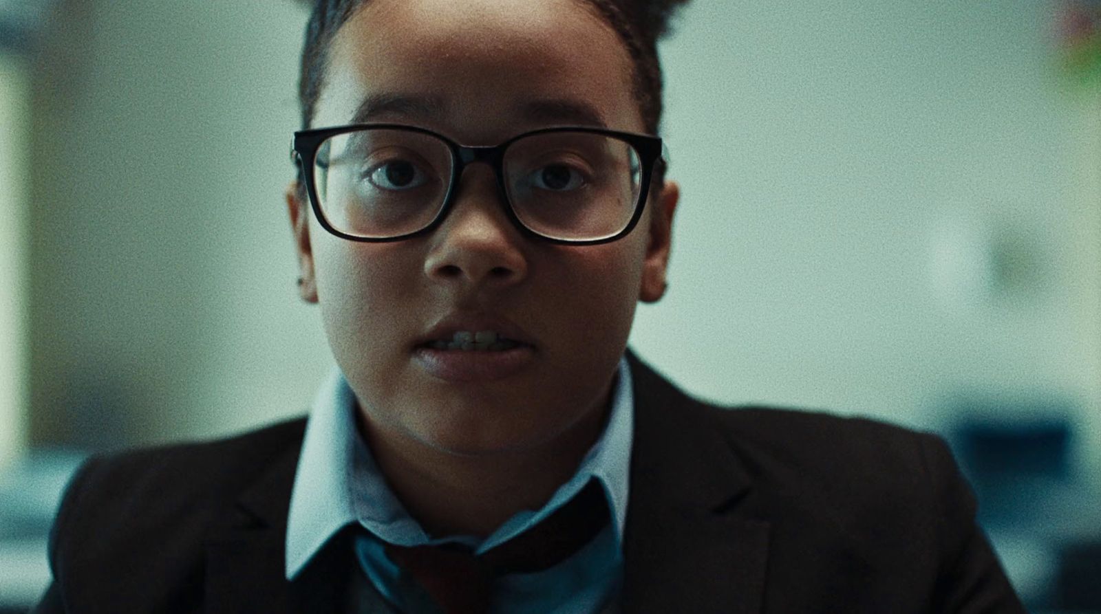 a young boy wearing glasses and a tie