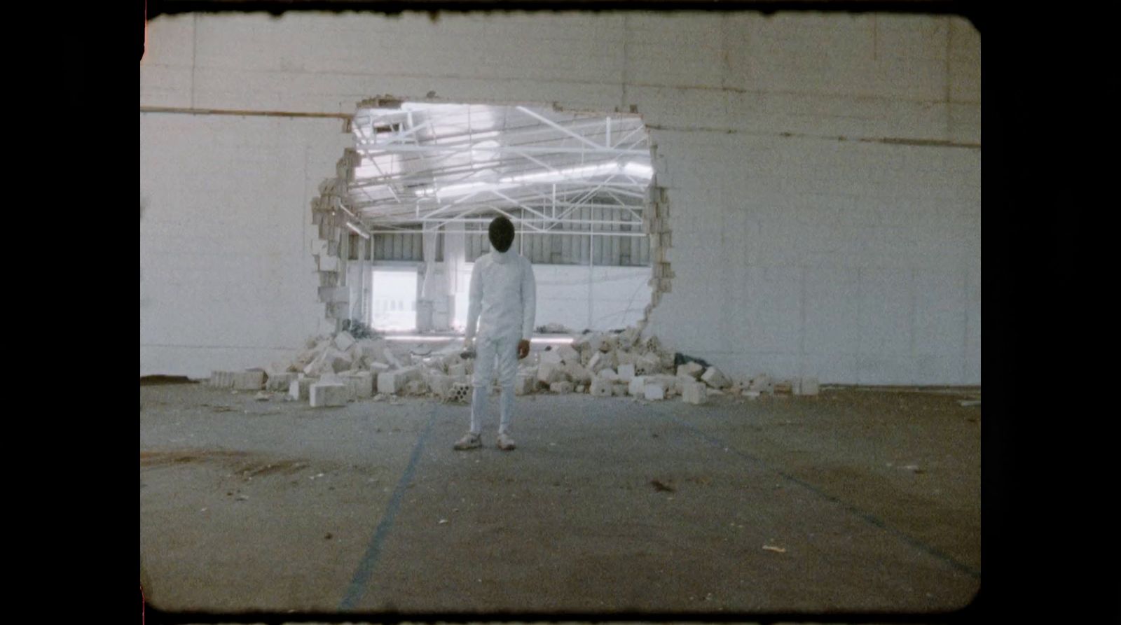 a man in a white suit standing in a room