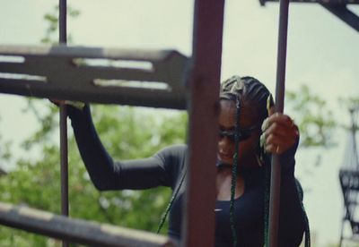 a woman holding onto the bars of a playground