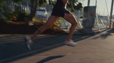 a man running down a street next to palm trees