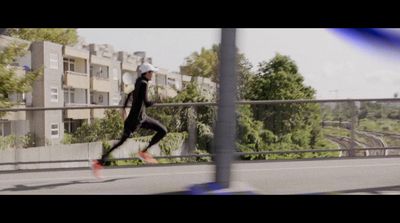 a man running down a street next to a tall building