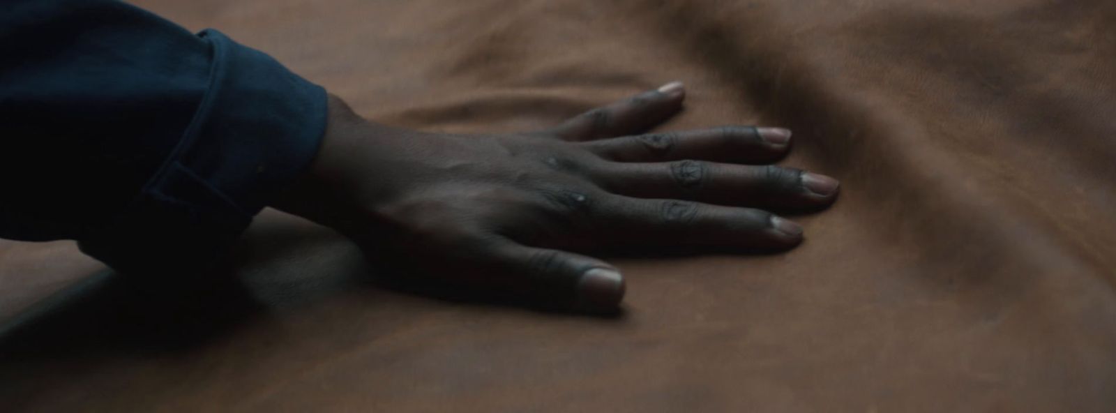 a person's hand on top of a bed