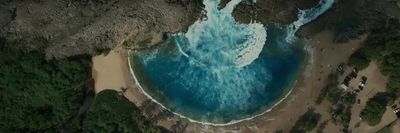 an aerial view of a beach with blue water