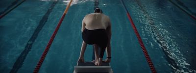 a person standing on a diving board in a swimming pool