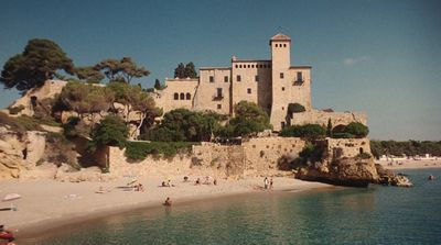 a castle on a cliff overlooking a beach