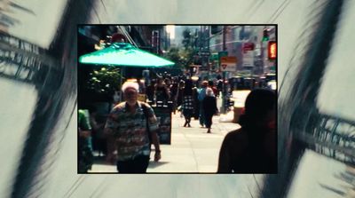 a group of people walking down a street next to tall buildings