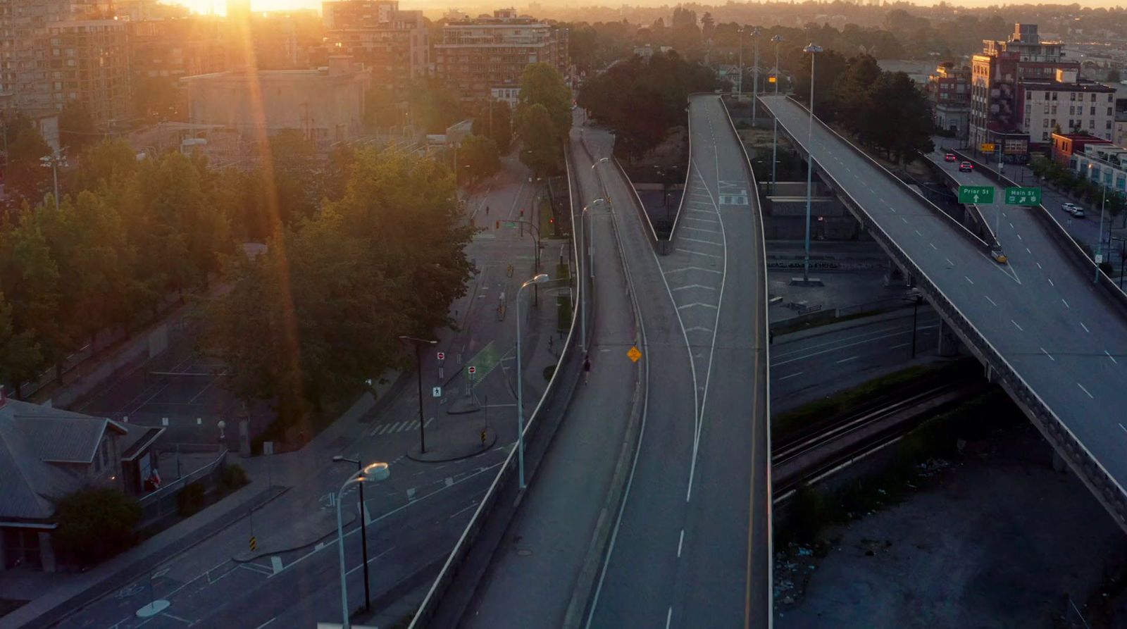 the sun is setting over a city street