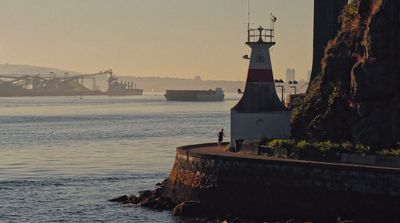 a light house sitting on the side of a body of water