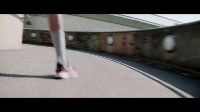 a person walking down a street next to a train