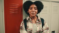 a woman standing in front of lockers in a locker