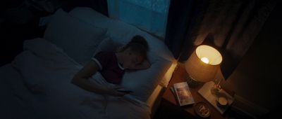 a woman laying in bed with her head on a pillow