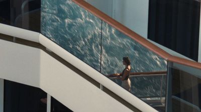 a woman standing on a balcony next to a railing