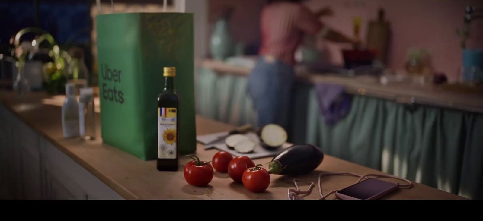 a counter with tomatoes and a bottle of wine